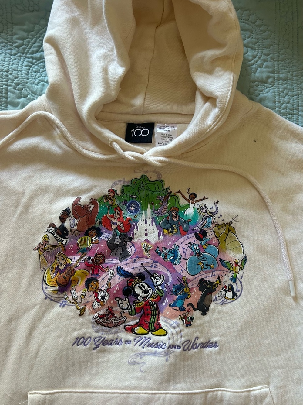 Disney Cream Hoodie with Colorful 100 Years of Music & Wonder Graphic